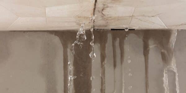 Water is dripping from the ceiling in a bathroom, indicating a leak that may require urgent attention.