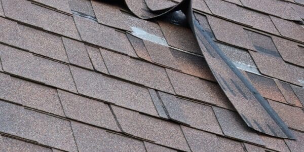 A roof displaying a broken piece of shingles, indicating potential damage or wear.